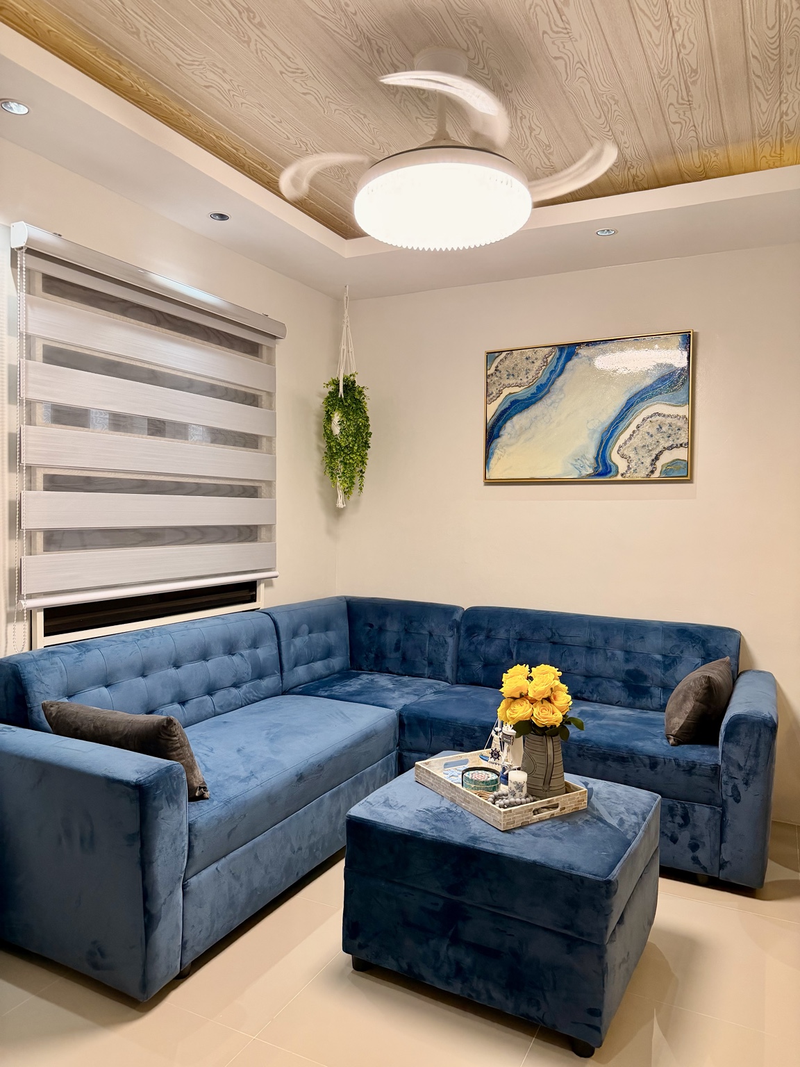 Casa Lucia living room with a blue sectional sofa and blue-and-gold resin artwork